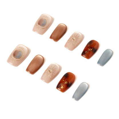 Lumi Loop handmade press-on nails in Desert Solstice, featuring a mix of tortoise shell, gold sunburst, and blue cat eye designs.