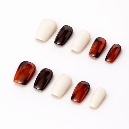 Angled side view of Lumi Loop handmade press-on nails featuring a mix of glossy tortoise shell pattern and solid cream beige in a square shape.